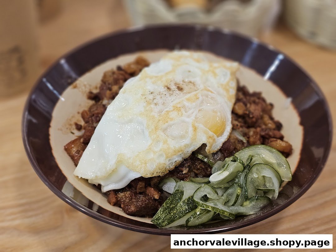 A delicious breakfast bowl featuring a fried egg, savory meat, and refreshing pickled cucumbers.