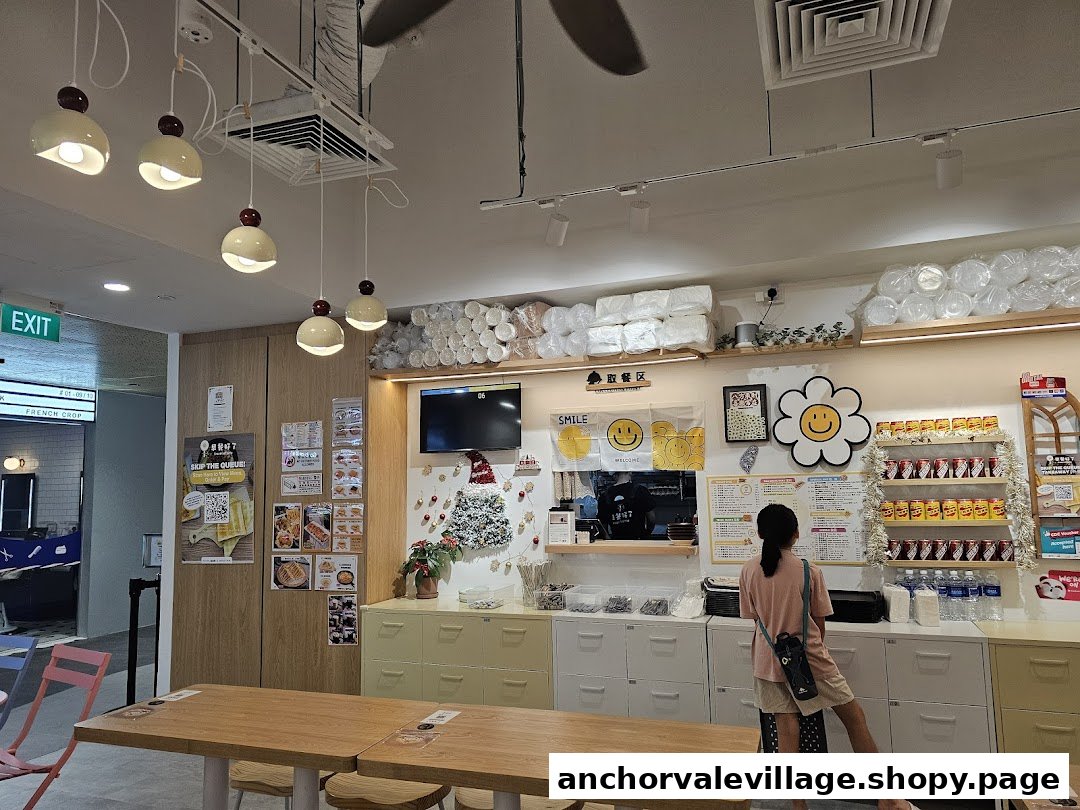 Interior view of Breakfast Hola, showing dining tables, a service counter, and a customer.