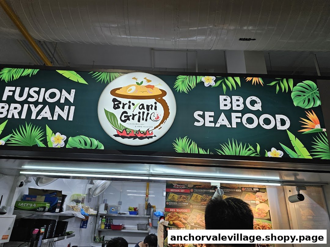 A food stall sign for Briyani Grill, offering fusion biryani and BBQ seafood, with a counter below.