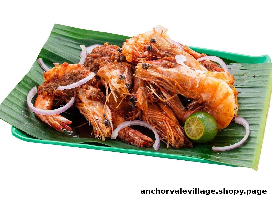 A vibrant dish of spicy prawns with onions and lime, served on a banana leaf.