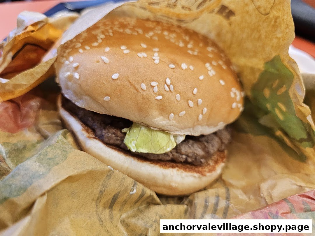 A close-up view of a classic Burger King burger, partially unwrapped.