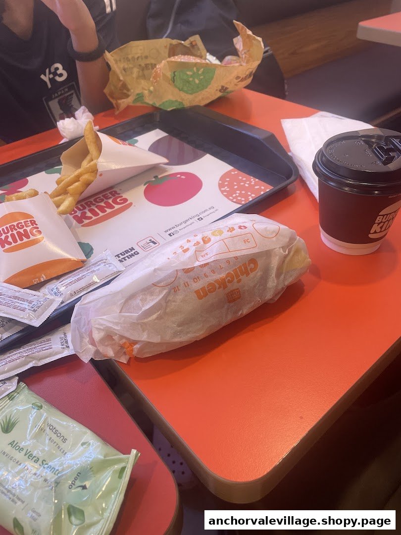 A table at Burger King with a meal including fries, a burger, a chicken item, and a drink.