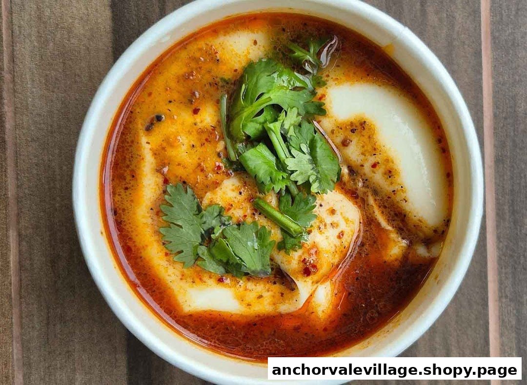 A close-up of a bowl of spicy dou hua (tofu pudding) topped with fresh cilantro.