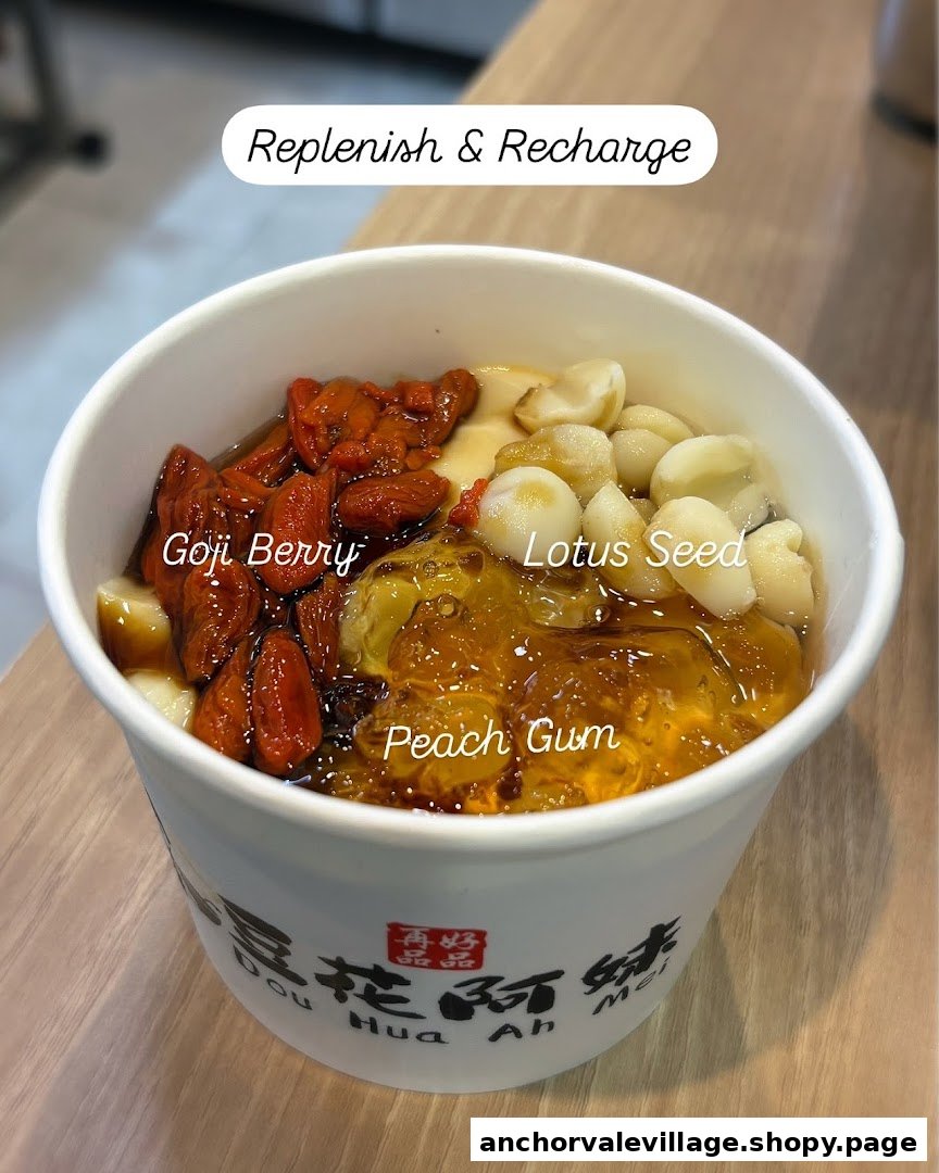 A close-up of a healthy Dou Hua dessert with goji berries, lotus seeds, and peach gum.