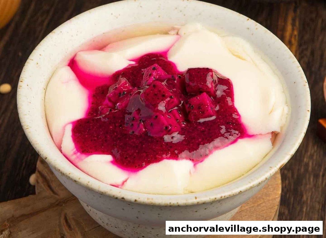 A close-up of a bowl of smooth dou hua (tofu pudding) topped with vibrant dragon fruit.