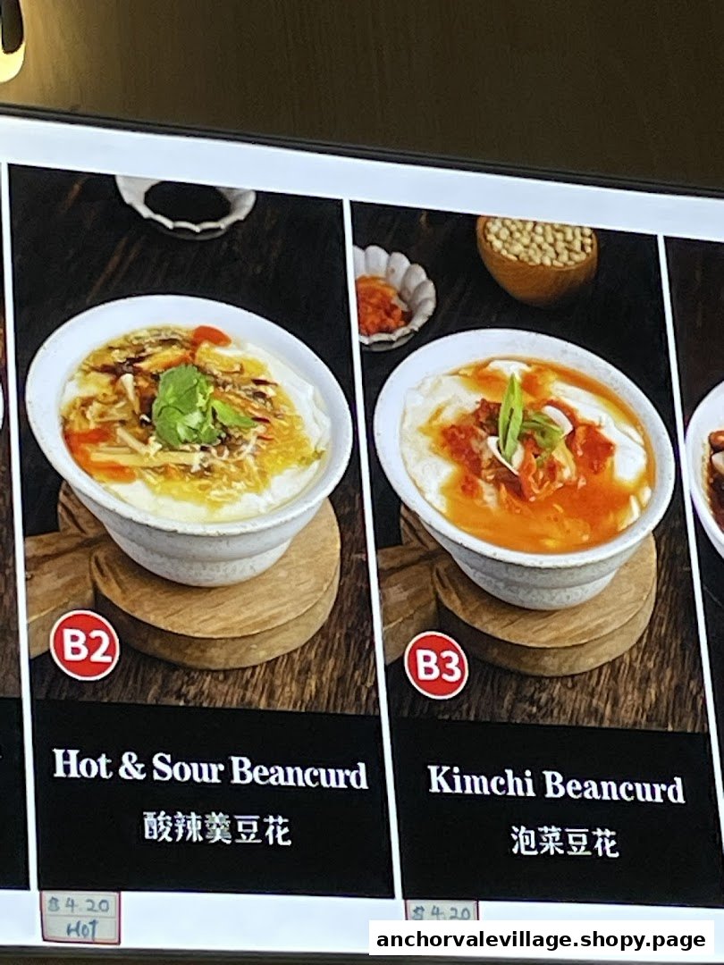 Close-up of a digital menu board displaying Hot & Sour Beancurd and Kimchi Beancurd dishes.