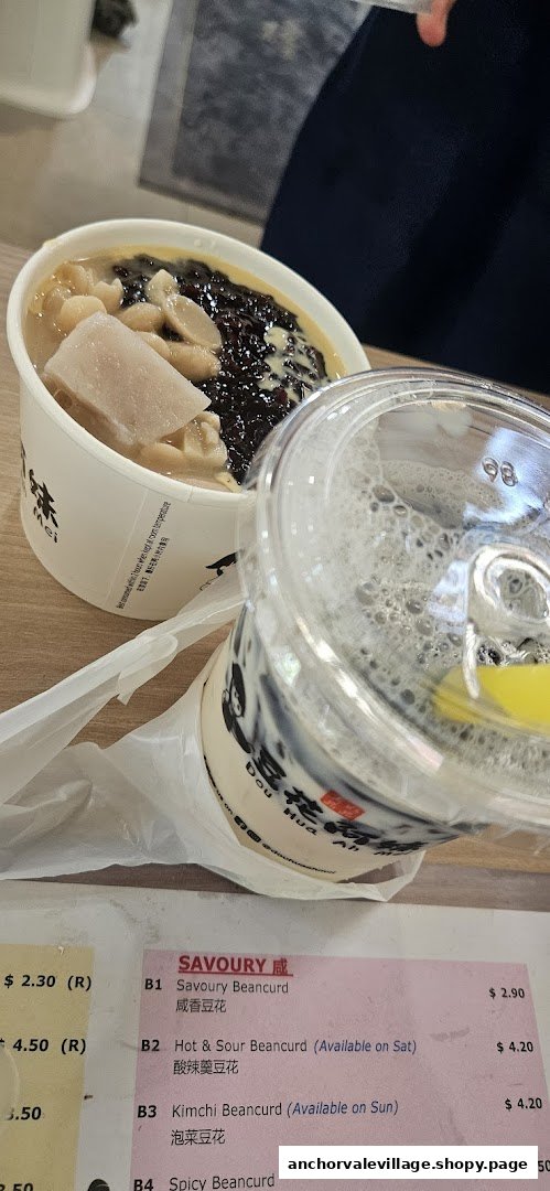 A bowl of beancurd dessert, a drink, and a partial menu displaying savoury beancurd options.