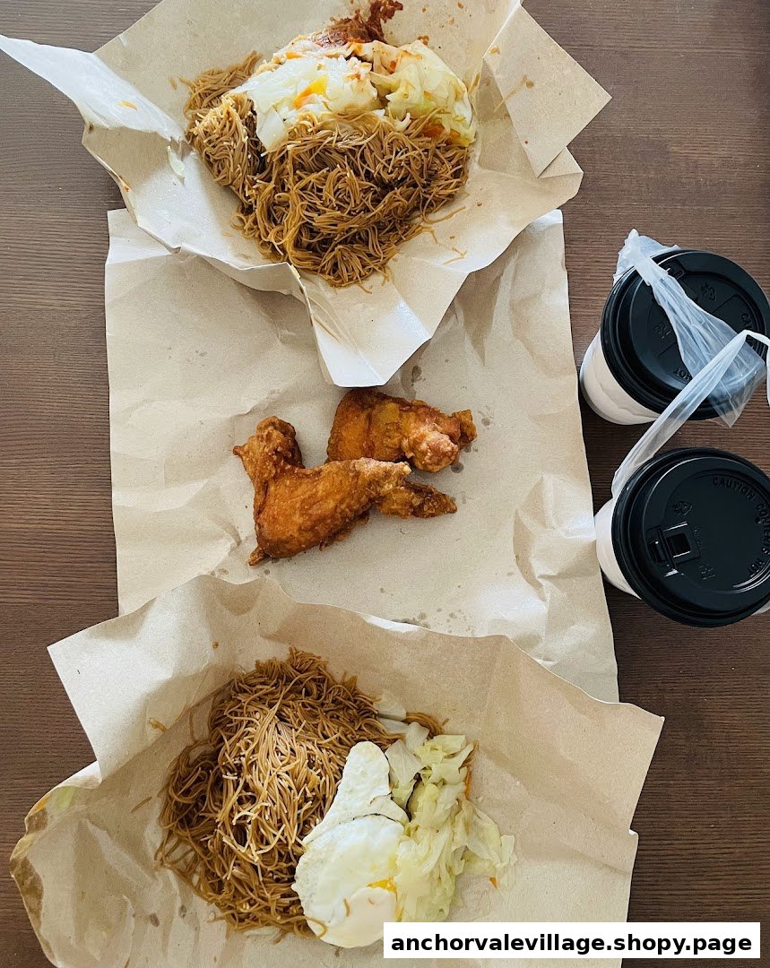 Delicious fried chicken wings, bee hoon, and fried eggs served with drinks on a table.