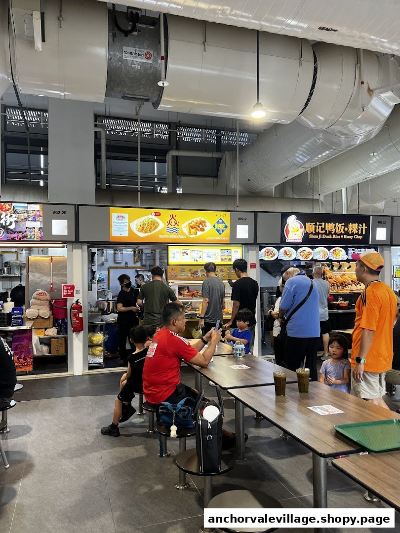 A bustling food court scene with multiple stalls, diners, and staff at Anchorvale Village.