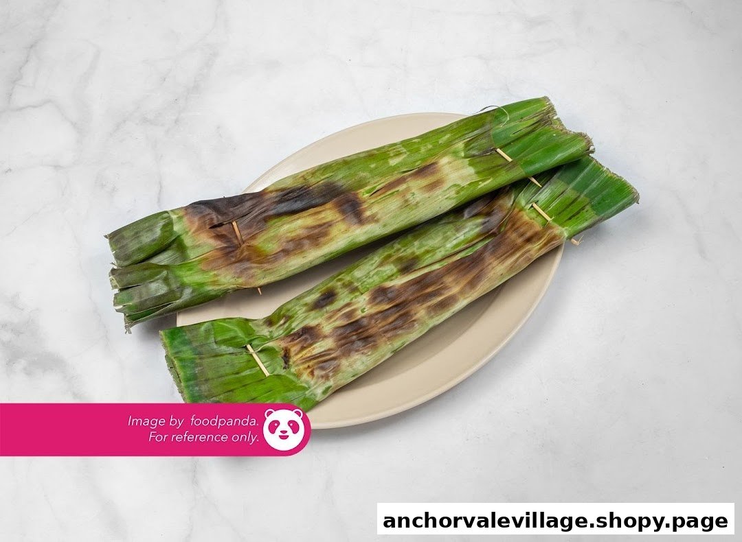 Two grilled banana leaf-wrapped snacks, likely otah, presented on a light-colored plate.