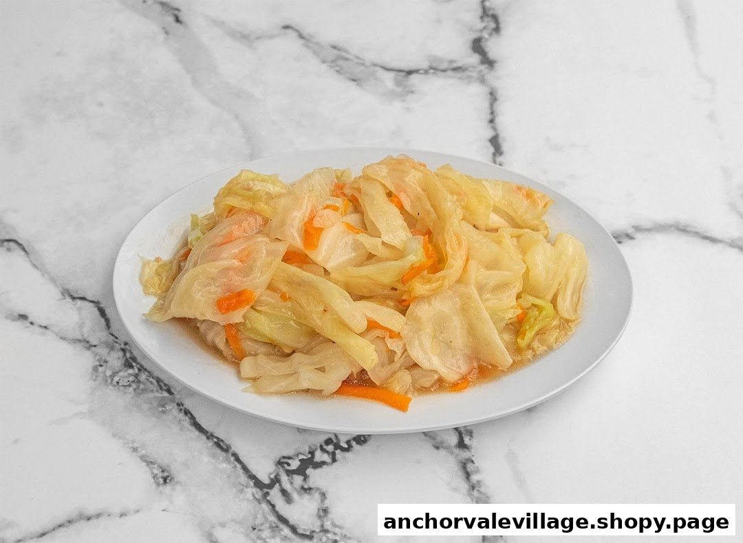 A white plate filled with stir-fried cabbage and carrots on a marble surface.