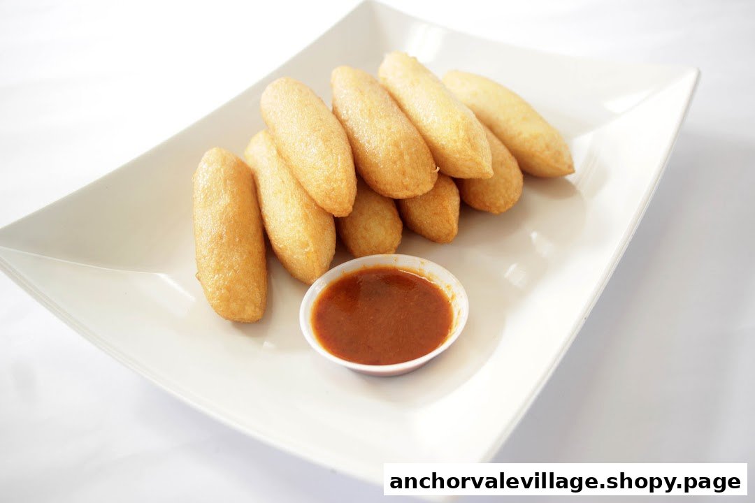 A plate of golden-brown fried fish cakes served with a small bowl of dipping sauce.