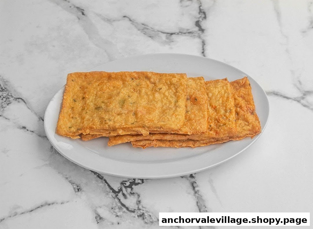 A plate of golden-brown, rectangular fried items, possibly fish cakes or tofu, on a white plate.