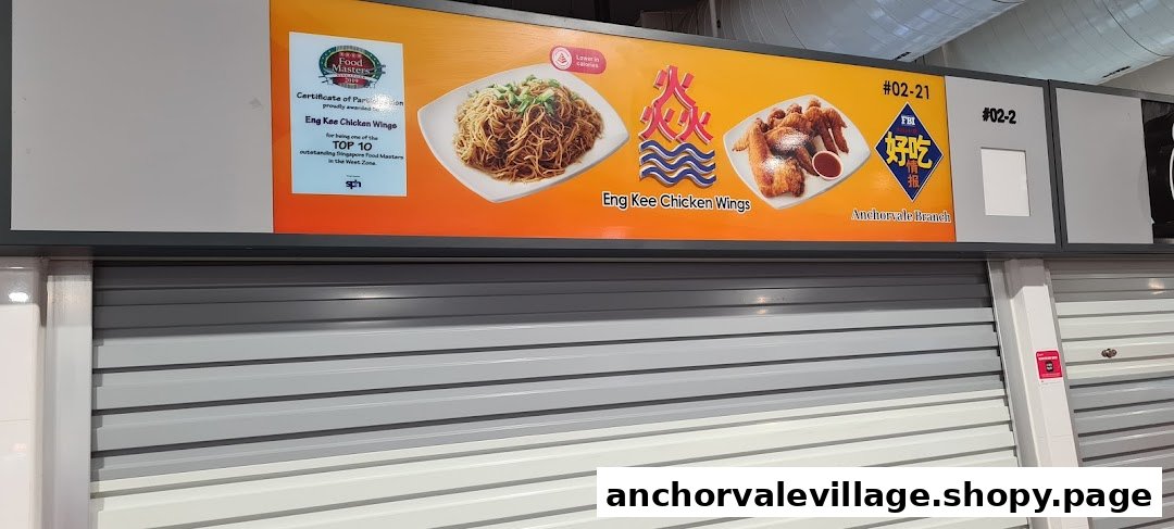 Signage for Eng Kee Chicken Wings featuring fried chicken and noodles, with a 'Top 10' award, above a closed shop.