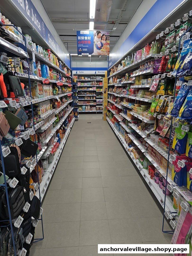 A long, well-stocked aisle inside FairPrice Anchorvale Village, featuring various groceries and household items.