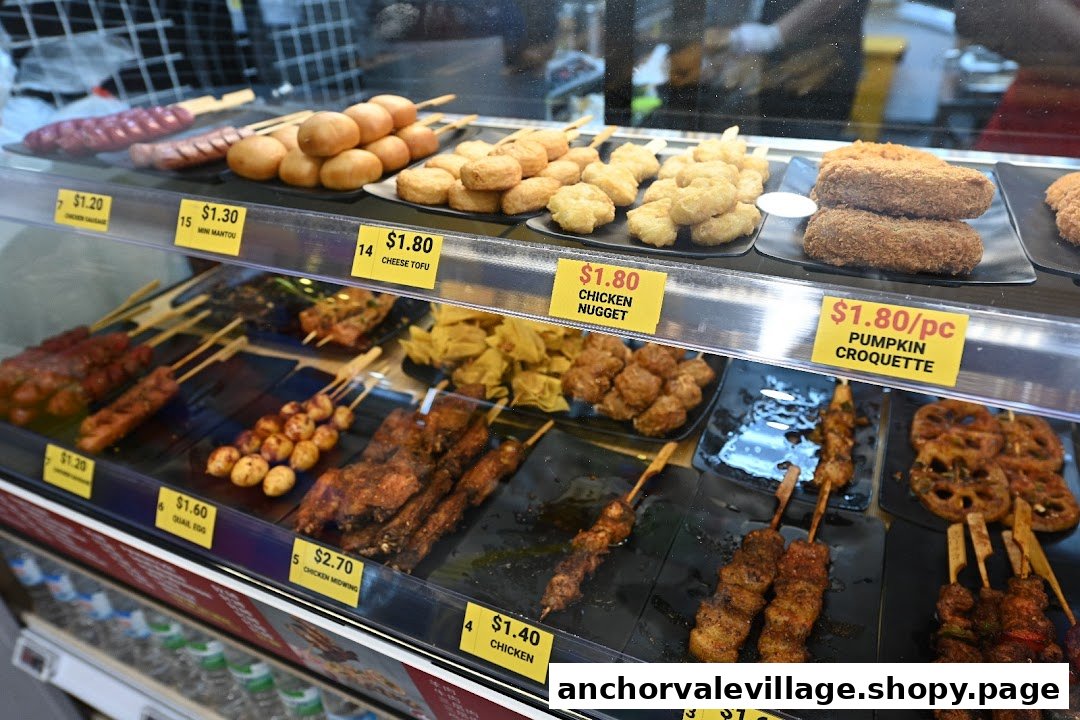 A display case filled with various ready-to-eat fried and skewered snacks with price tags.