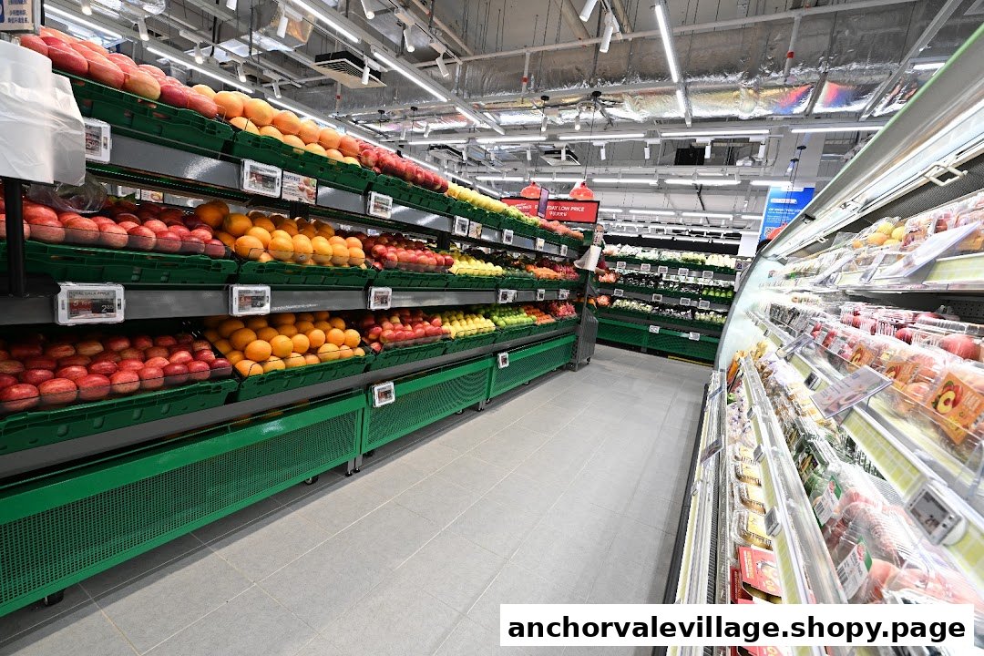 An aisle inside FairPrice Anchorvale Village supermarket, showcasing fresh fruits and vegetables on display.
