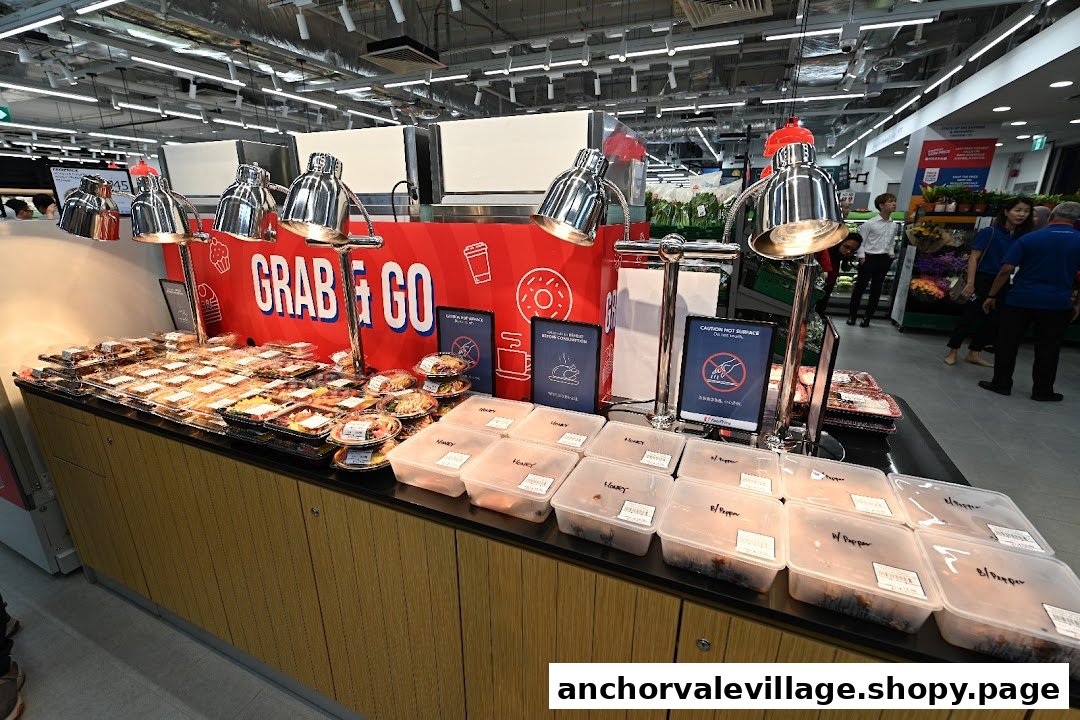 A well-lit 'Grab & Go' section at FairPrice, offering a variety of pre-packaged meals and hot food.