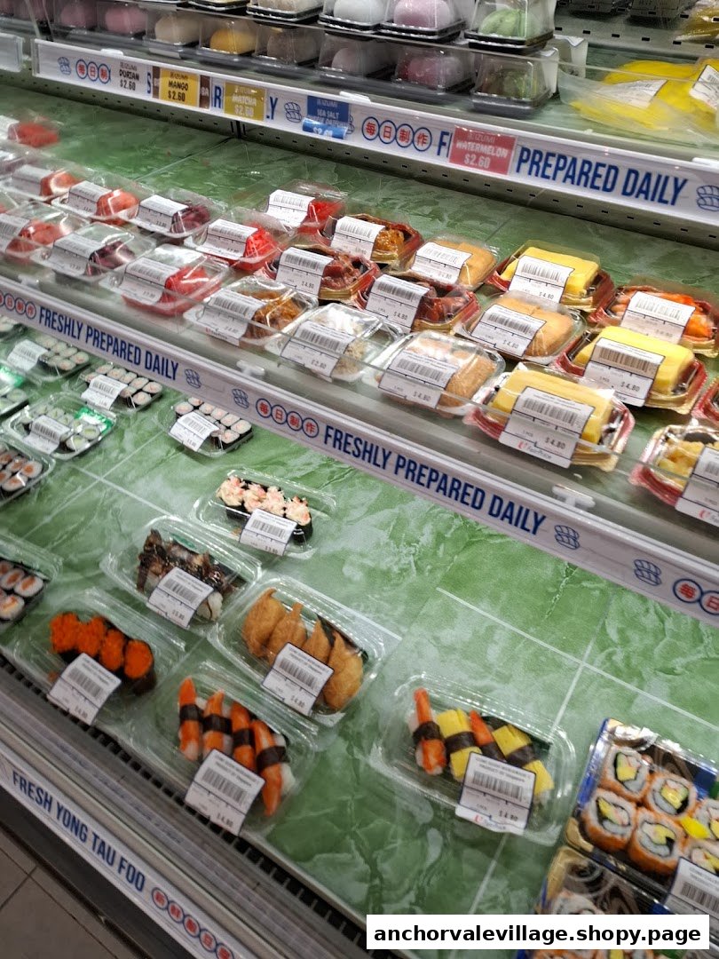 A refrigerated display case at FairPrice showcasing various freshly prepared sushi, mochi, and other ready-to-eat items.