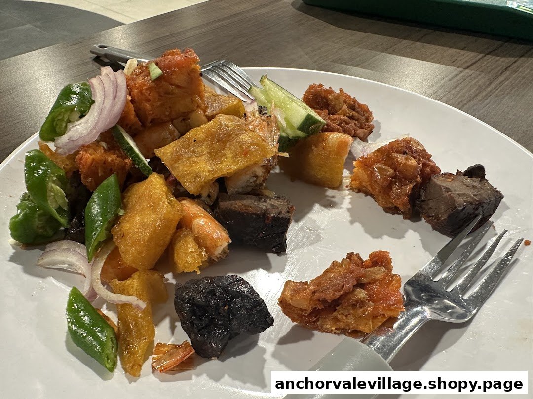 A close-up of a delicious plate of rojak with assorted ingredients and a fork.