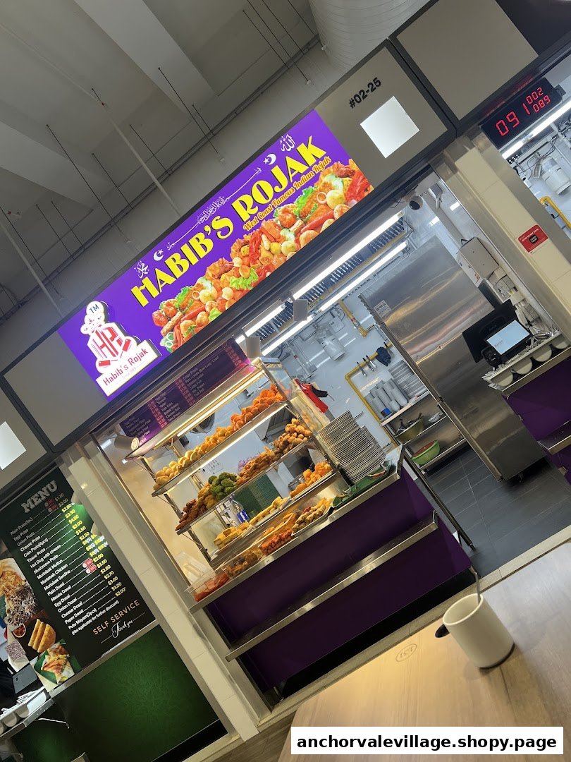 A vibrant counter at Habib's Rojak showcasing various Indian snacks and a detailed menu board.