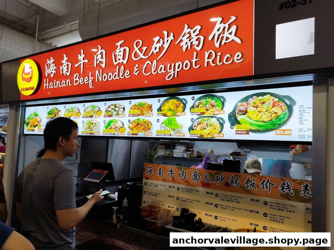 A customer at the counter of Hainan Beef Noodle & Claypot Rice, with menu boards displaying dishes and prices.