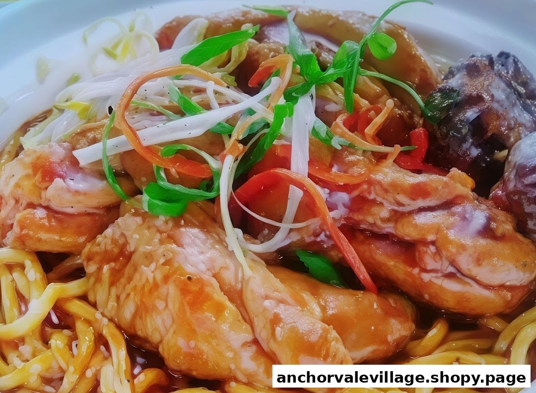 A close-up of a delicious noodle dish featuring tender meat, fresh vegetables, and a rich sauce.