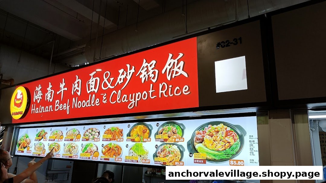 A vibrant menu board displaying various Hainan beef noodle and claypot rice dishes with prices.