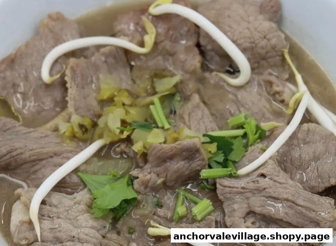 Close-up of a hearty bowl of beef noodles with bean sprouts, pickled vegetables, and fresh herbs.