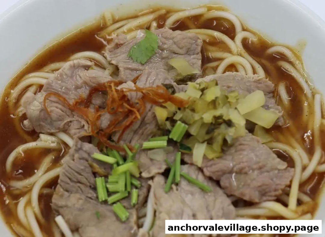 A close-up of a delicious bowl of beef noodles with broth, sliced beef, and various toppings.