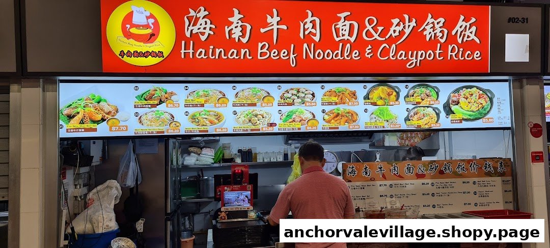 A food stall's digital menu board displaying various Hainan beef noodle and claypot rice dishes with prices.