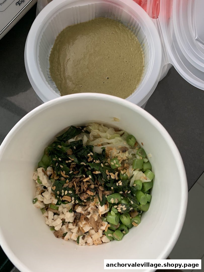 A bowl of Hakka Lei Cha ingredients with a separate container of green tea soup.