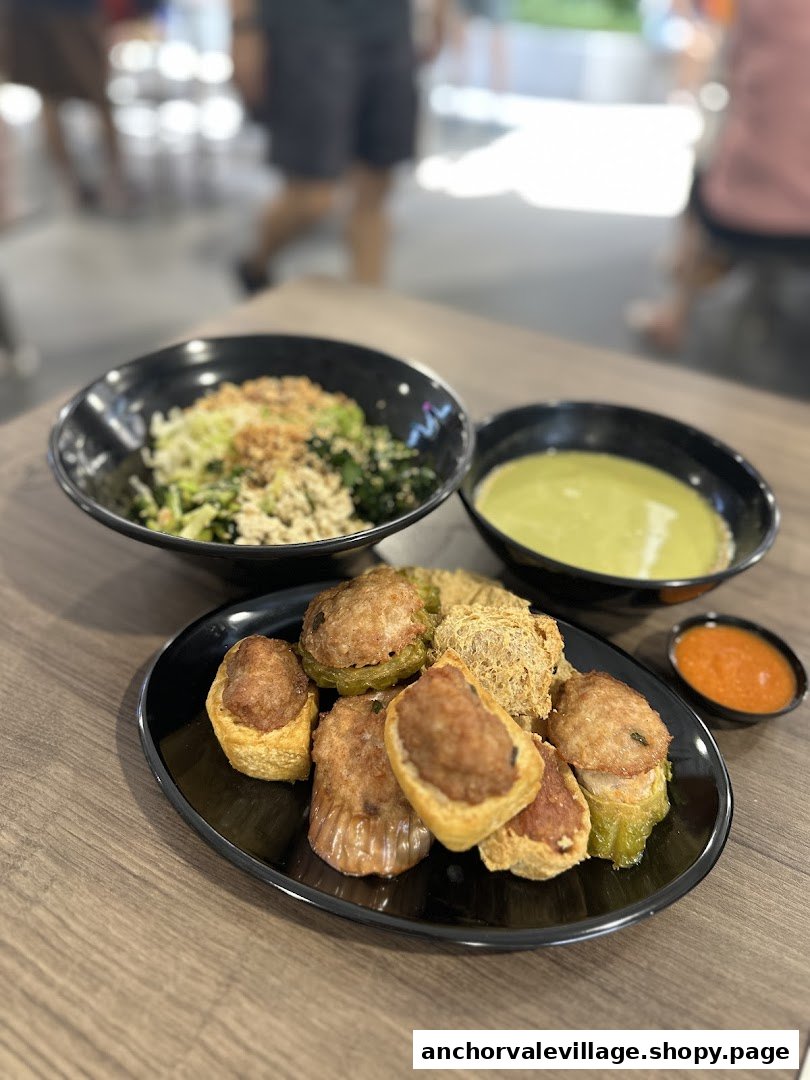 A delicious spread of Hakka Yong Tau Foo, Lei Cha, and a bowl of rice/noodles on a wooden table.