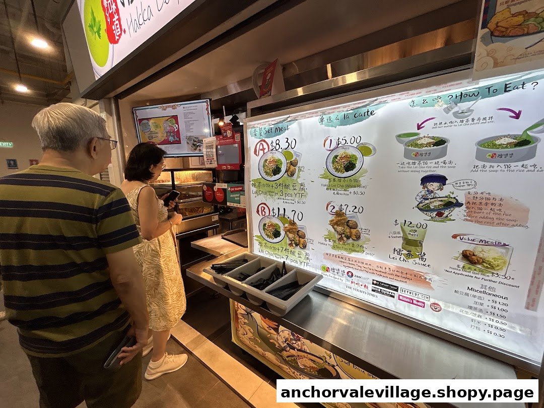 Customers at Hakka Leipopo, viewing a brightly lit menu board displaying various Hakka dishes and prices.