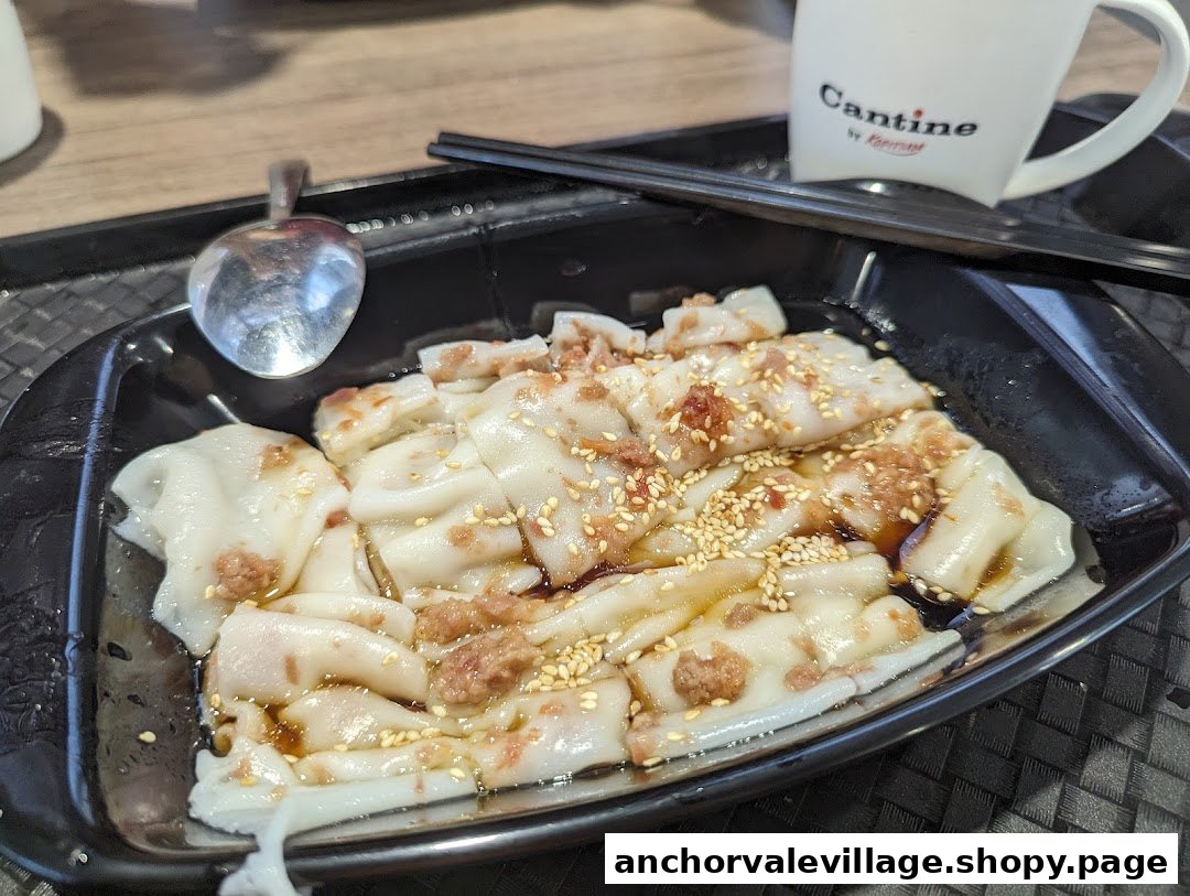 A close-up of delicious Hong Kong style Chee Cheong Fun with savory sauce and sesame seeds.