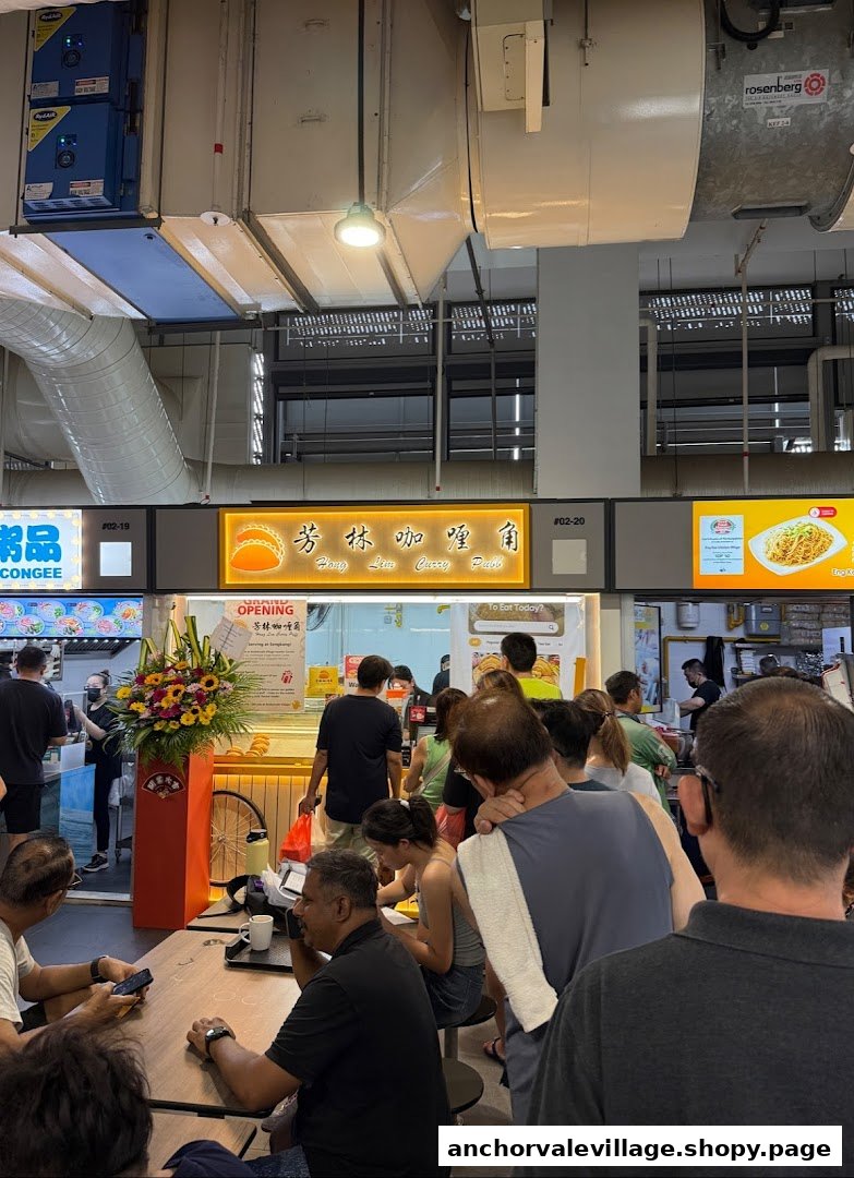 Customers queue and dine at the popular Hong Lim Curry Puff stall in a bustling food court.