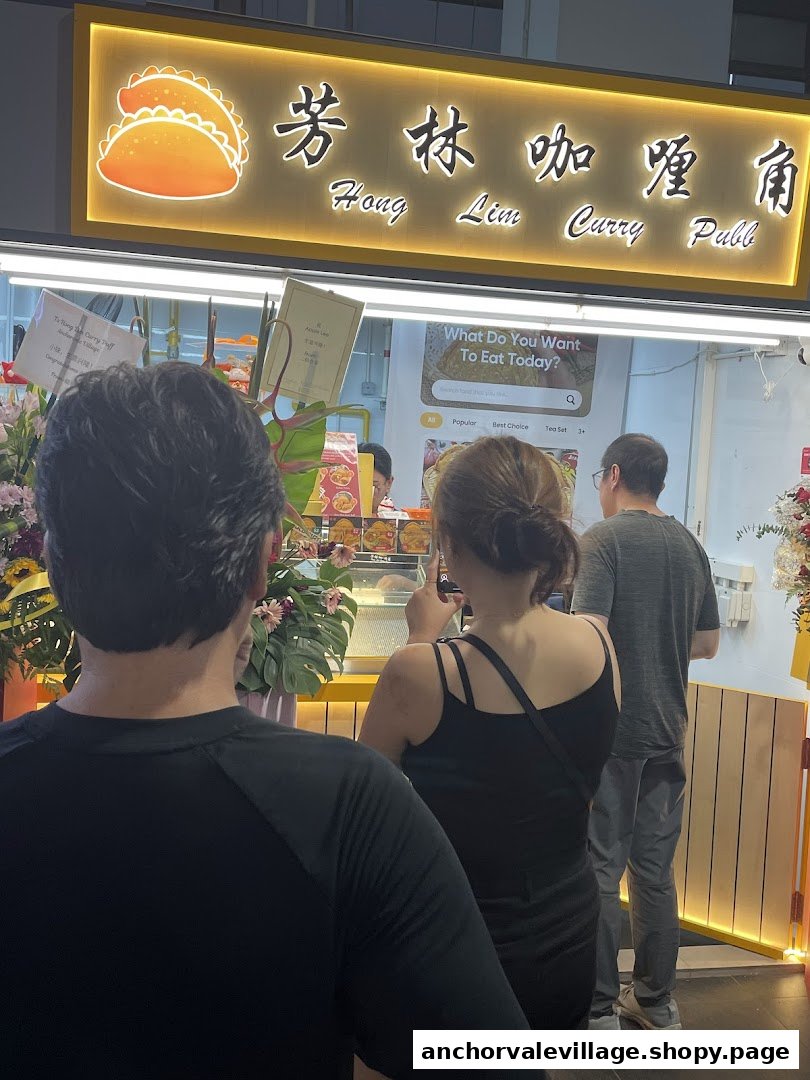 Customers queueing at the brightly lit Hong Lim Curry Puff shop front.