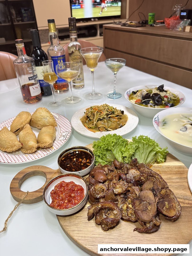 A vibrant table spread featuring curry puffs, various dishes, and an assortment of alcoholic beverages.