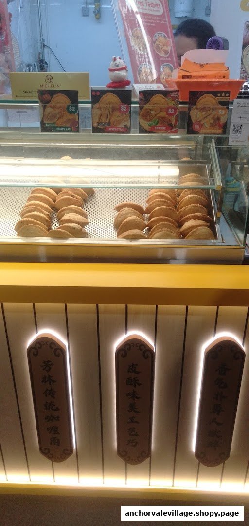 A display counter showcasing various curry puffs with price tags and Michelin recognition.