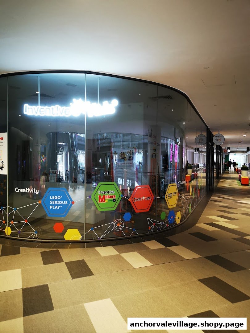 The curved glass storefront of Inventive Kids Play-based STEM Learning Centre, featuring colorful educational decals.