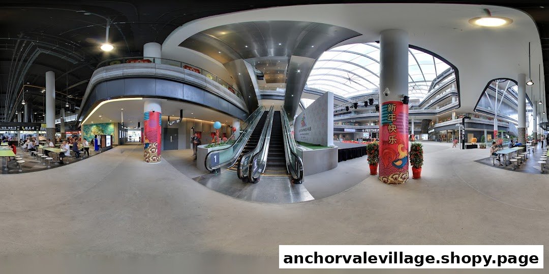 A panoramic view of a modern shopping mall interior featuring escalators, a food court, and multiple retail levels.