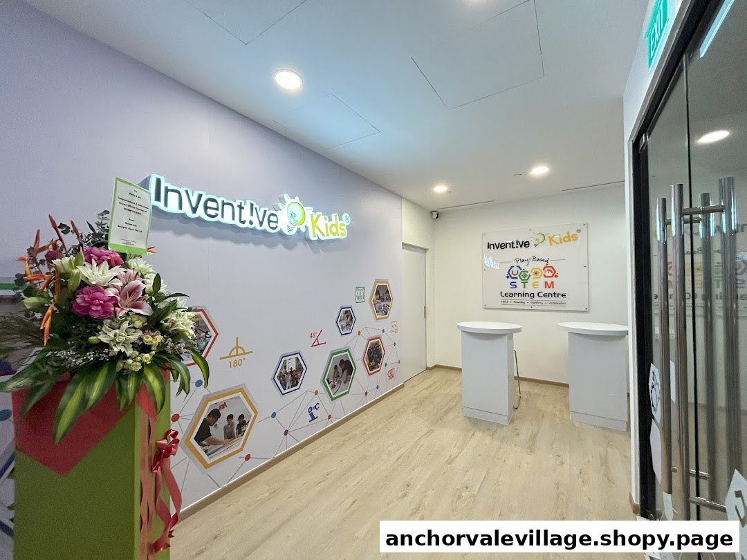 The bright and inviting entrance lobby of Inventive Kids Play-based STEM Learning Centre, featuring branding and a floral display.