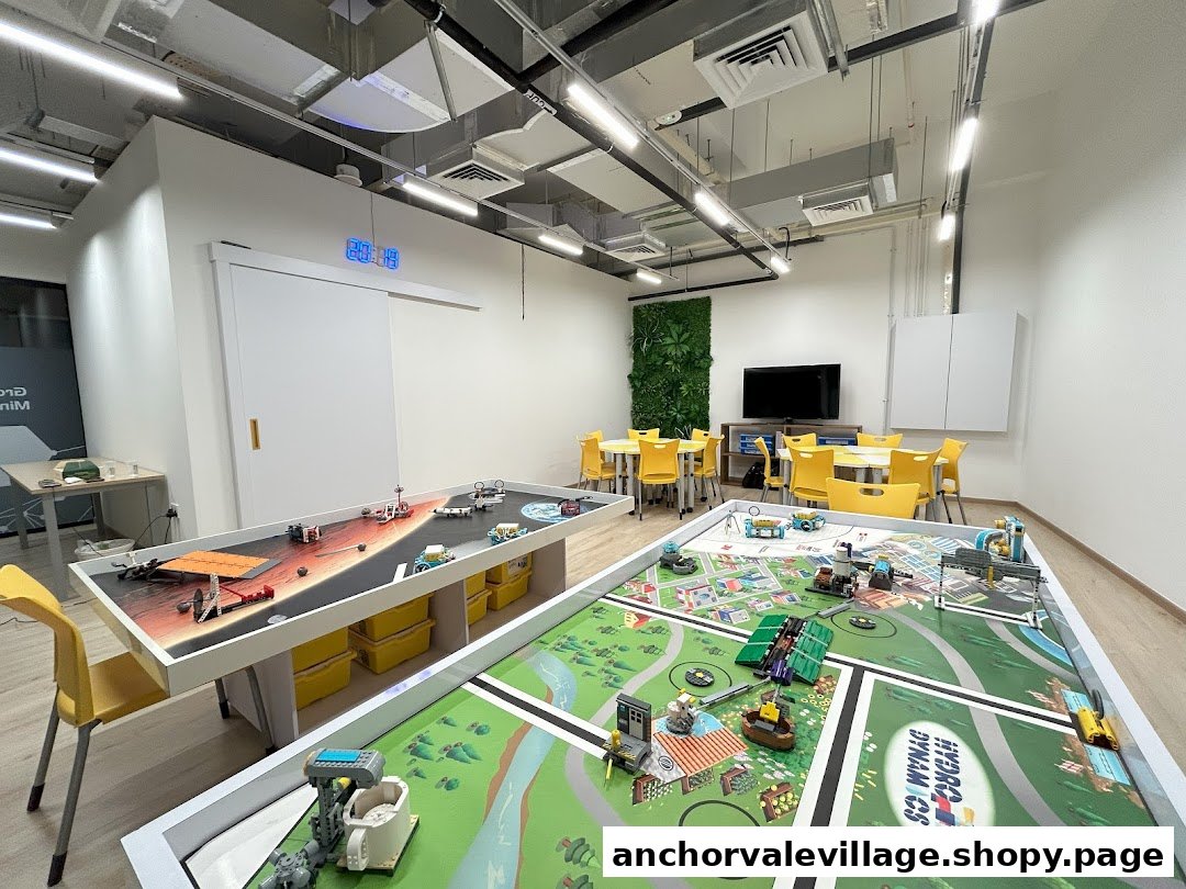 A bright, modern STEM learning center interior with robotics tables, interactive setups, and yellow seating.