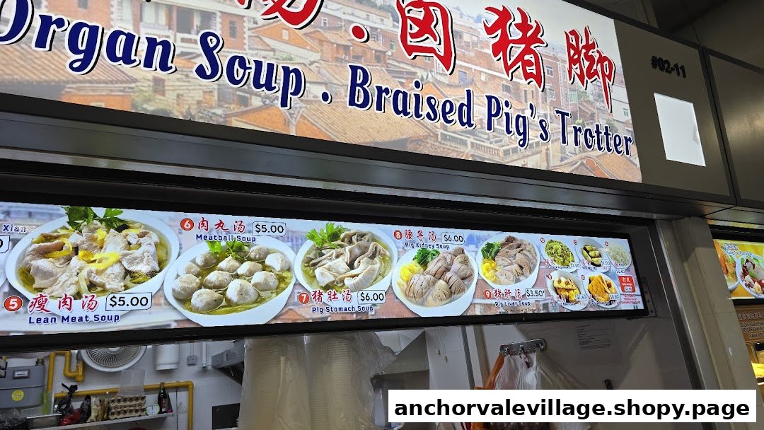 A brightly lit menu board displaying various pig organ soups and their prices at a food stall.