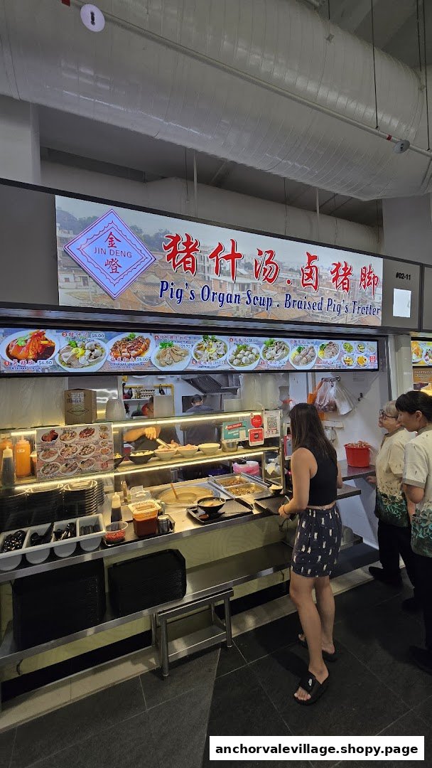 A bustling food stall counter at Jin Deng, serving traditional pig's organ soup and braised pig's trotters.