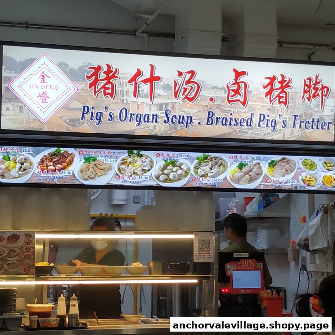 A brightly lit signboard and menu display for Jin Deng Pigs Organ Soup and Braised Pig's Trotter.