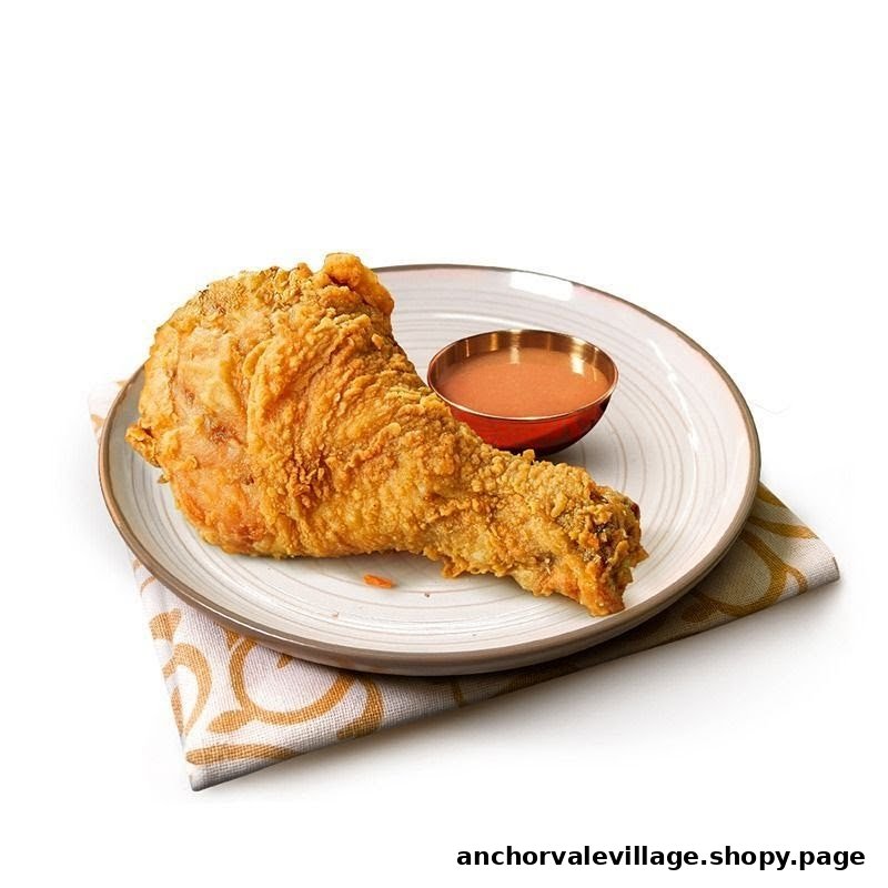 A crispy fried chicken leg with dipping sauce on a plate, ready to be enjoyed.