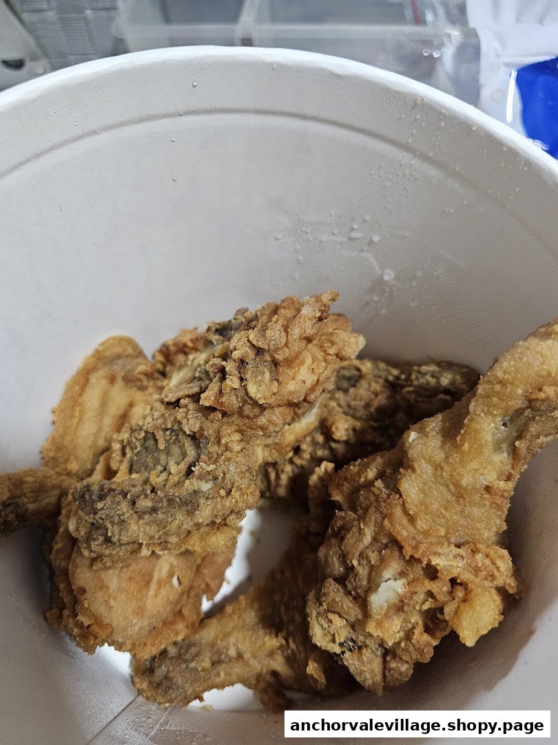Close-up of crispy fried chicken pieces in a white bucket from Jollibee.