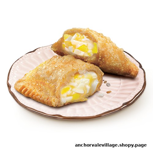 Two golden-fried pies with creamy white and yellow fruit filling, one cut open, on a pink plate.