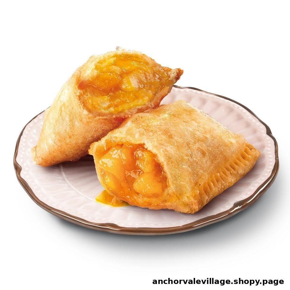 Two golden-fried fruit pies, one cut open to reveal a vibrant orange filling, served on a small plate.